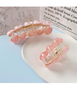 Detail of pink transparent shark hair clips with shell texture on a white tray