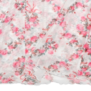 Gros plan détaillé du tissu en maille blanche avec imprimés roses et bord ondulé