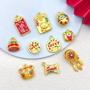 Detailed view of gold enamel lucky cat and fortune bag charms for DIY jewelry making