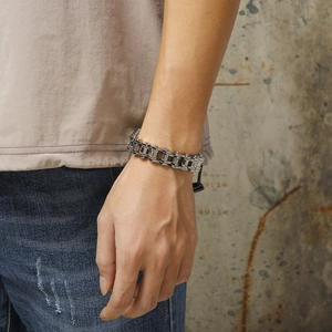 Close-up of a silver stainless steel motorcycle chain bracelet worn on a male wrist