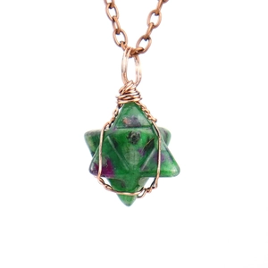 Detailed macro view of handmade copper wire-wrapped star-shaped ruby in zoisite pendant