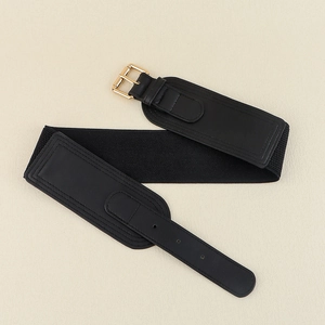 Detail of black wide elastic waist belt featuring a square gold metal pin buckle closure