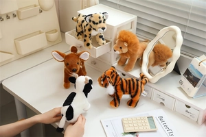 Detailed view of soft plush animal dolls including leopard, lion and deer on a desk