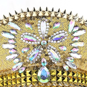 Macro detail of sparkly gold sequins and colorful rhinestones on festive cosplay hat