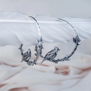 Artistic vintage silver hoop earrings with birds and leaf design on feathers