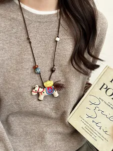 Detail of embroidered horse pendant with wood beads on long brown necklace