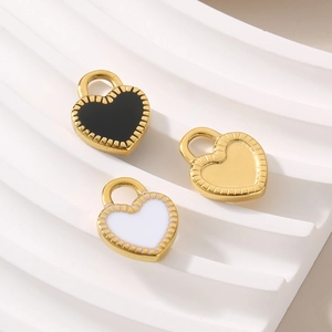 Detailed view of heart-shaped enamel charms in black, white, and gold finishes