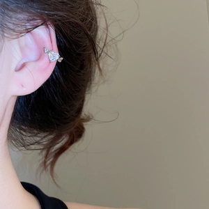 Detail of silver heart wing ear cuff with clear cubic zirconia on ear cartilage