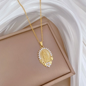 Macro view of gold-plated Madonna oval pendant with sparkling crystals on silk fabric