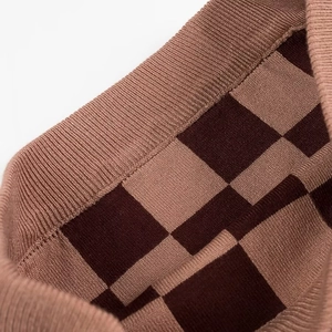 Détail du tissu en maille à damier marron foncé montrant la texture du tricot