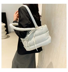 Détail du sac cabas matelassé à rayures bleu clair avec nœud sur la bandoulière