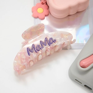 Close-up of pink marble hair claw clip with purple rhinestone MaMa letter design