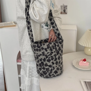 Detail of the leopard print plush bucket bag with magnetic closure and soft shoulder strap