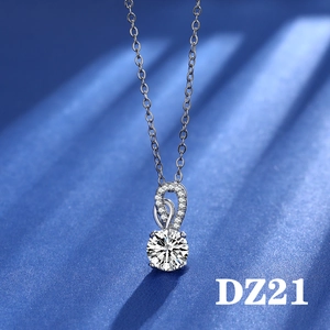 Detail of a 2-carat round cut stone pendant on an O-chain over dark blue fabric