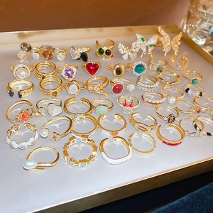 Close-up of assorted gold-plated dragon and gemstone rings on a golden display tray