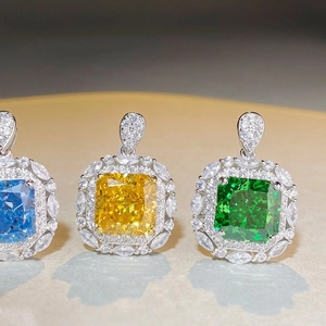 Macro view of square cushion cut pendants in blue, yellow and green with halo diamonds