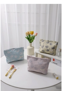Close-up of pastel swan jacquard makeup bags in light blue, lilac and beige colors