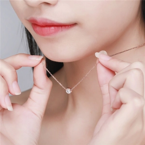 Minimalist rose gold titanium necklace with single round zircon on woman's collarbone