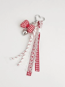 Detail van rood-witte ruitjes strik sleutelhanger met hart en diverse linten