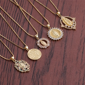 Set of five gold plated religious necklaces with CZ micro pave pendants on wood background