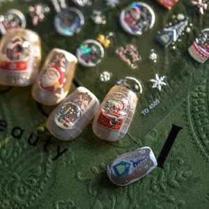 Macro shot of 3D Christmas nail stickers with Santa Claus and snow globe patterns