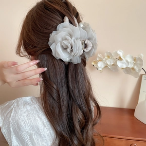 Détail d'une grande pince à cheveux rose en tulle avec perle pour coiffure élégante