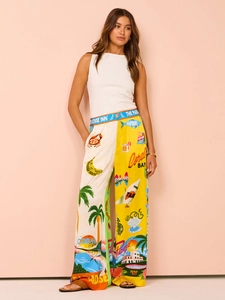 Detail of high-waist wide-leg pants with tropical palm tree print and satin finish