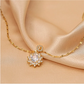 Close-up of a gold floral necklace with sparkling zircon petals on silk fabric