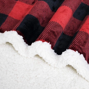 Close-up of red and black plaid flannel blanket with soft white sherpa fleece lining