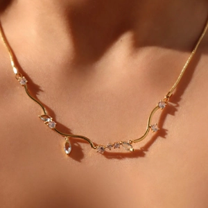 Detailed view of 18k gold plated Cuban chain necklace with tassels and blue crystals