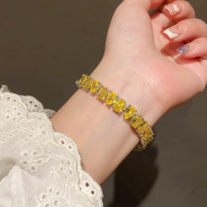 Macro shot of an adjustable silver bracelet featuring pear-cut yellow zircon stones