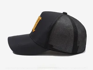 Side view of black mesh trucker hat with gold gothic embroidery and breathable structure