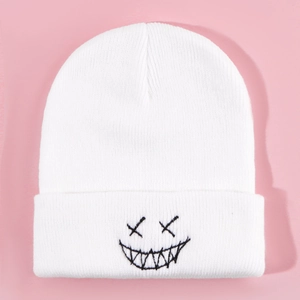 White knitted beanie with black embroidered punk face design on pink background