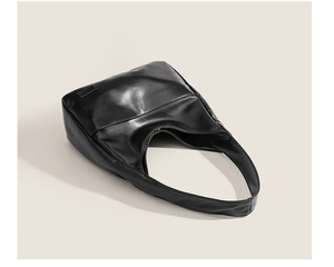 Detailed side view of black leather hobo bag showing smooth texture and clean stitching
