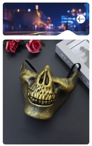 Close-up of bronze skull mask with antique finish and elastic strap on dark background