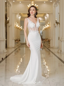 Close-up of deep V-neck lace bodice and intricate floral embroidery on mermaid wedding gown