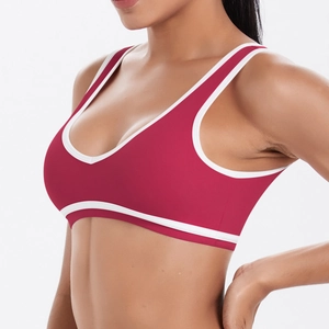 Détail d'une brassière de sport rouge avec passepoil blanc et col en V élastique