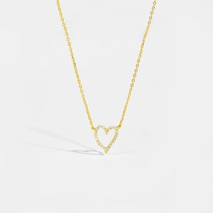 Close-up of golden S925 sterling silver necklace with hollow heart pendant and white zircons