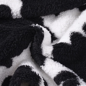 Close-up of soft cow print plush fabric texture and thick faux fur material detail