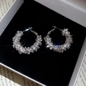 Minimalist silver irregular C-shaped hoop earrings with shimmering pavé crystal diamonds
