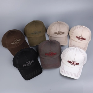 Detailed flat lay of baseball caps in seven colors with embroidered letter patterns