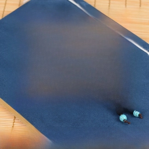 Macro detail of 0.8cm Ebony 108 beads bracelet with turquoise spacers on bamboo mat