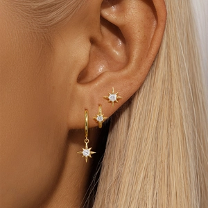 Close-up of S925 silver gold-plated octagram star earrings set with crystals on model