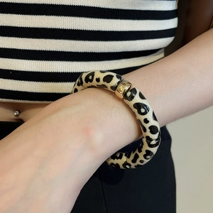 Detail of vintage leopard print resin bracelet with decorative gold metal bead