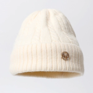 Classic cream knit beanie featuring thick cable patterns and a gold M letter emblem