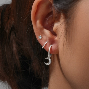 Detail of silver S925 moon and star earring set with crystals on ear lobe