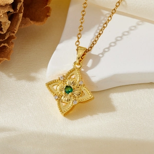 Détail du pendentif fleur vintage avec pierre verte sur tissu en soie et décor de pierre