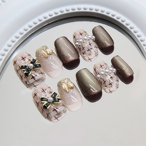 Faux ongles œil-de-chat marron avec nœuds 3D, perles et motif tweed élégant