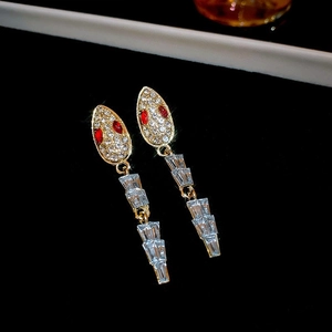 Makroansicht goldene Schlangenohrringe mit Diamanten und roten Kristallaugen