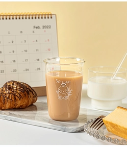 Detail of cute puppy illustration on a glass cup used for milk tea on marble tray